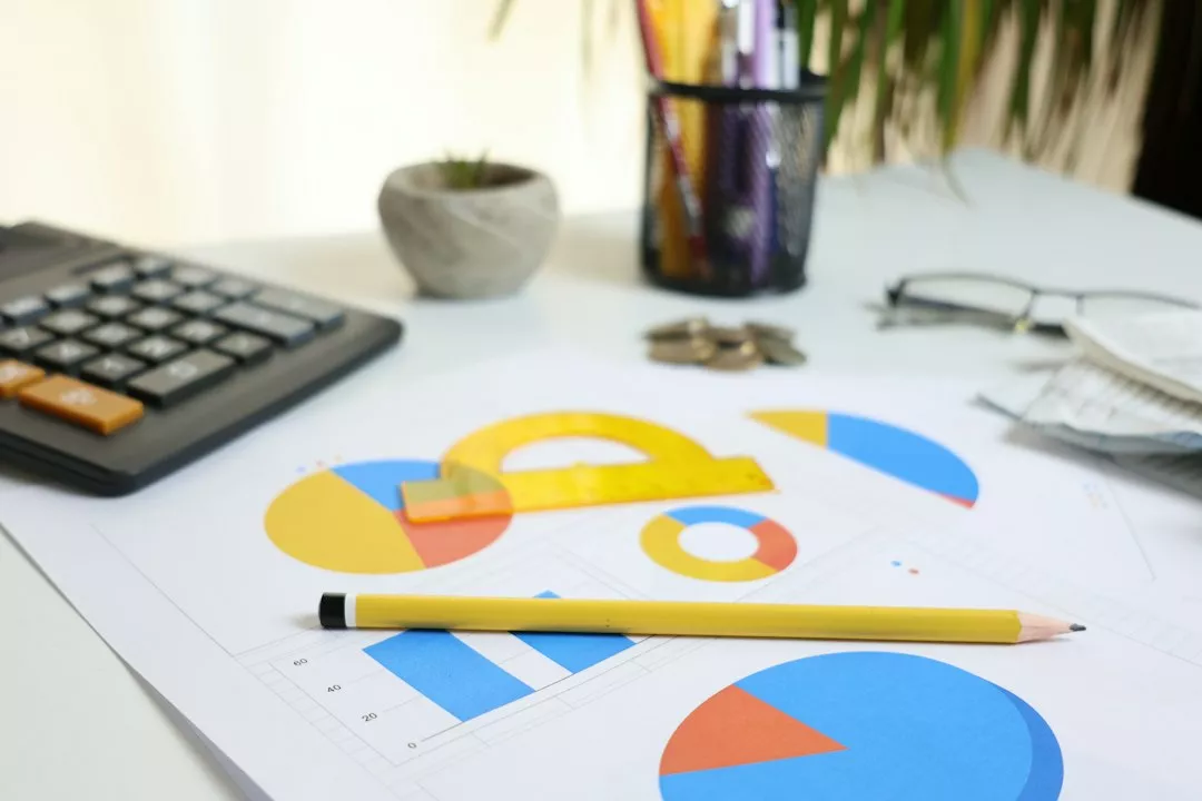 Desk with calculator, charts, and pencil