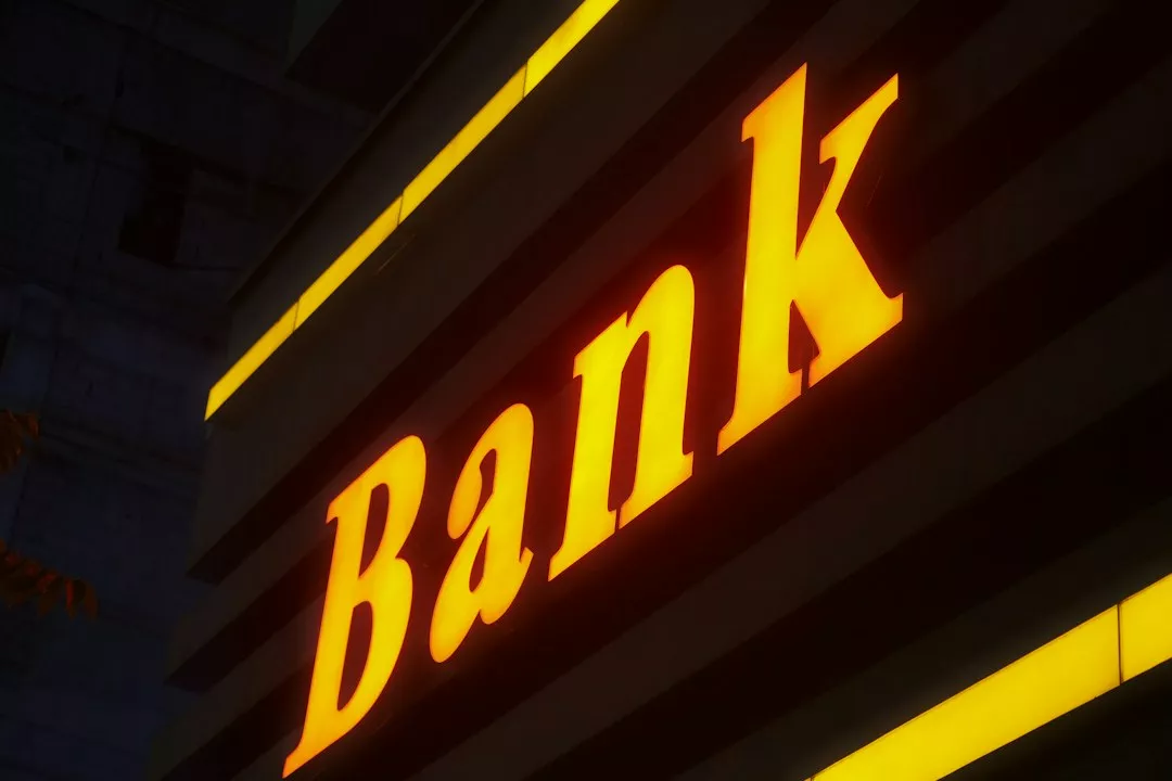 a bank sign lit up in the dark